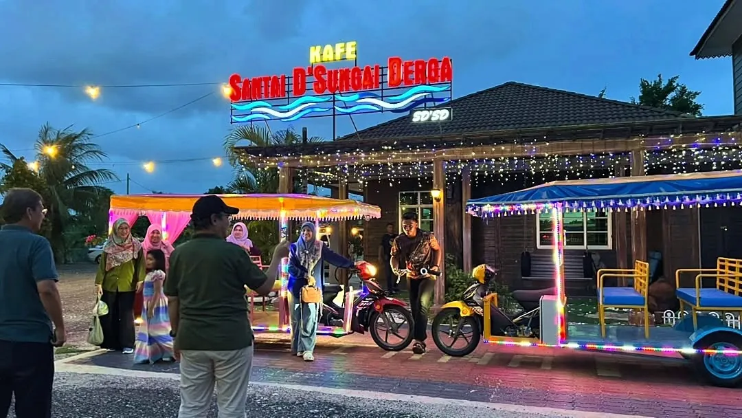 Papan tanda Kafe Santai D'Sungai Derga bercahaya waktu malam